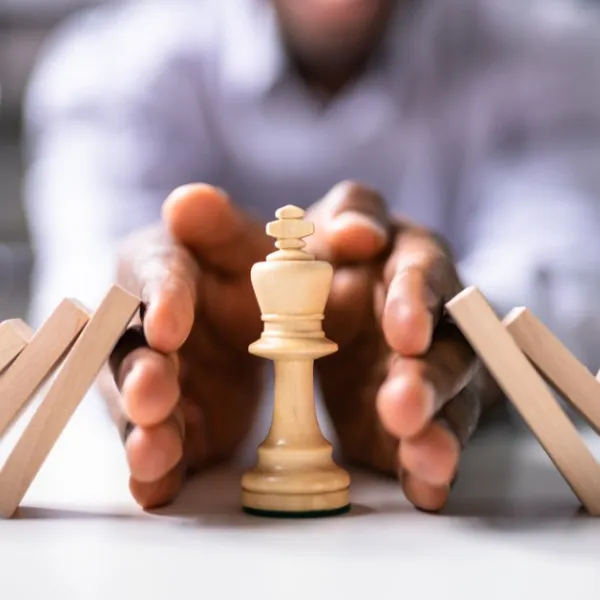 Immagine che contiene persona, mani, che proteggono pezzo degli scacchi da pezzi di legno